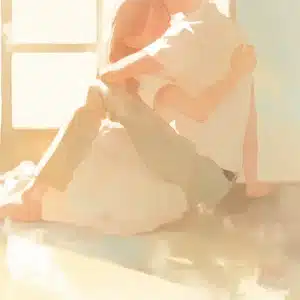 Et intimt og kærligt øjeblik mellem to personer badet i varmt lys – symbol på ro, kontakt og nydelse i et hypnoseforløb ved seksuelle udfordringer.